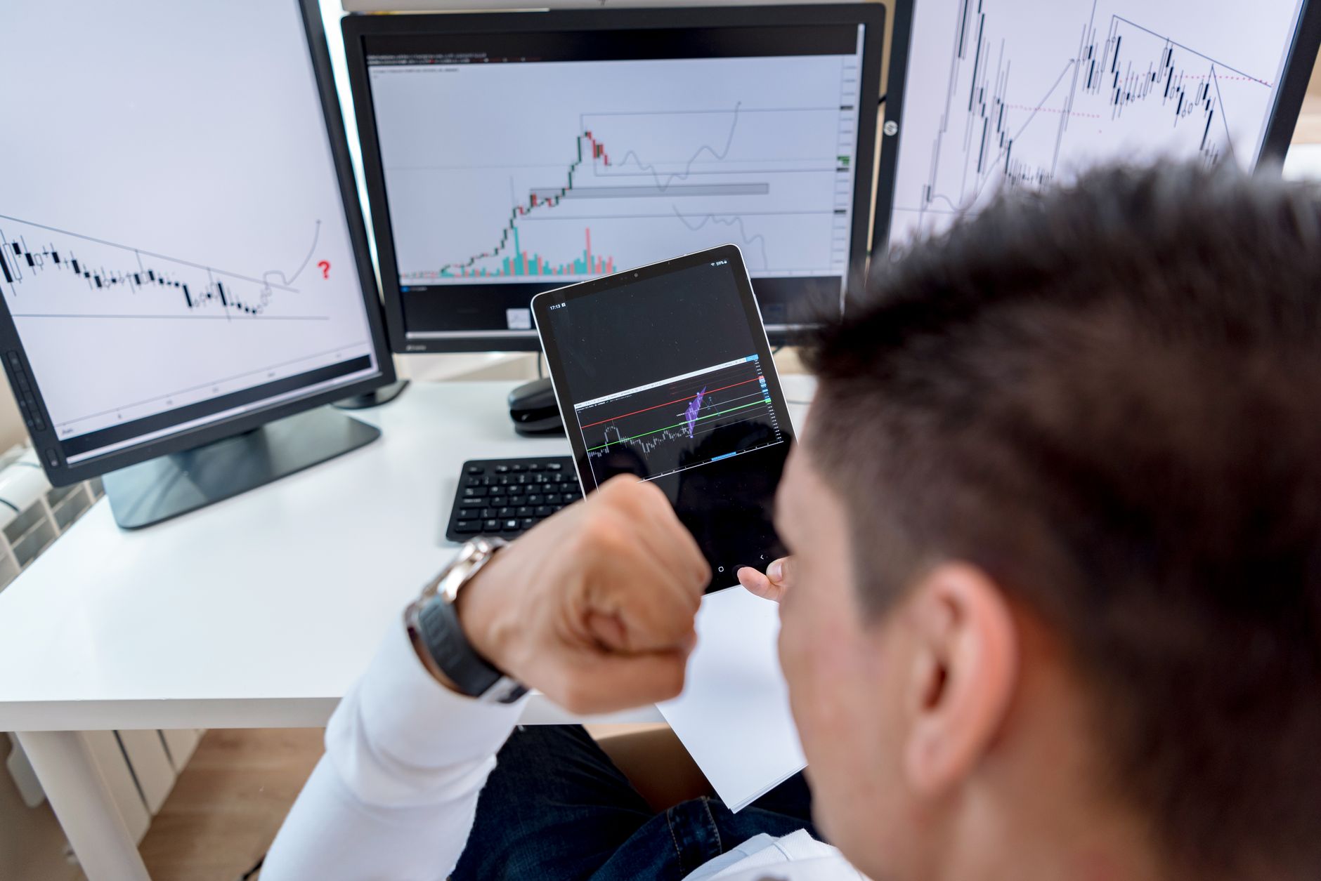 Trader analyzing live futures charts across multiple monitors at a prop trading desk